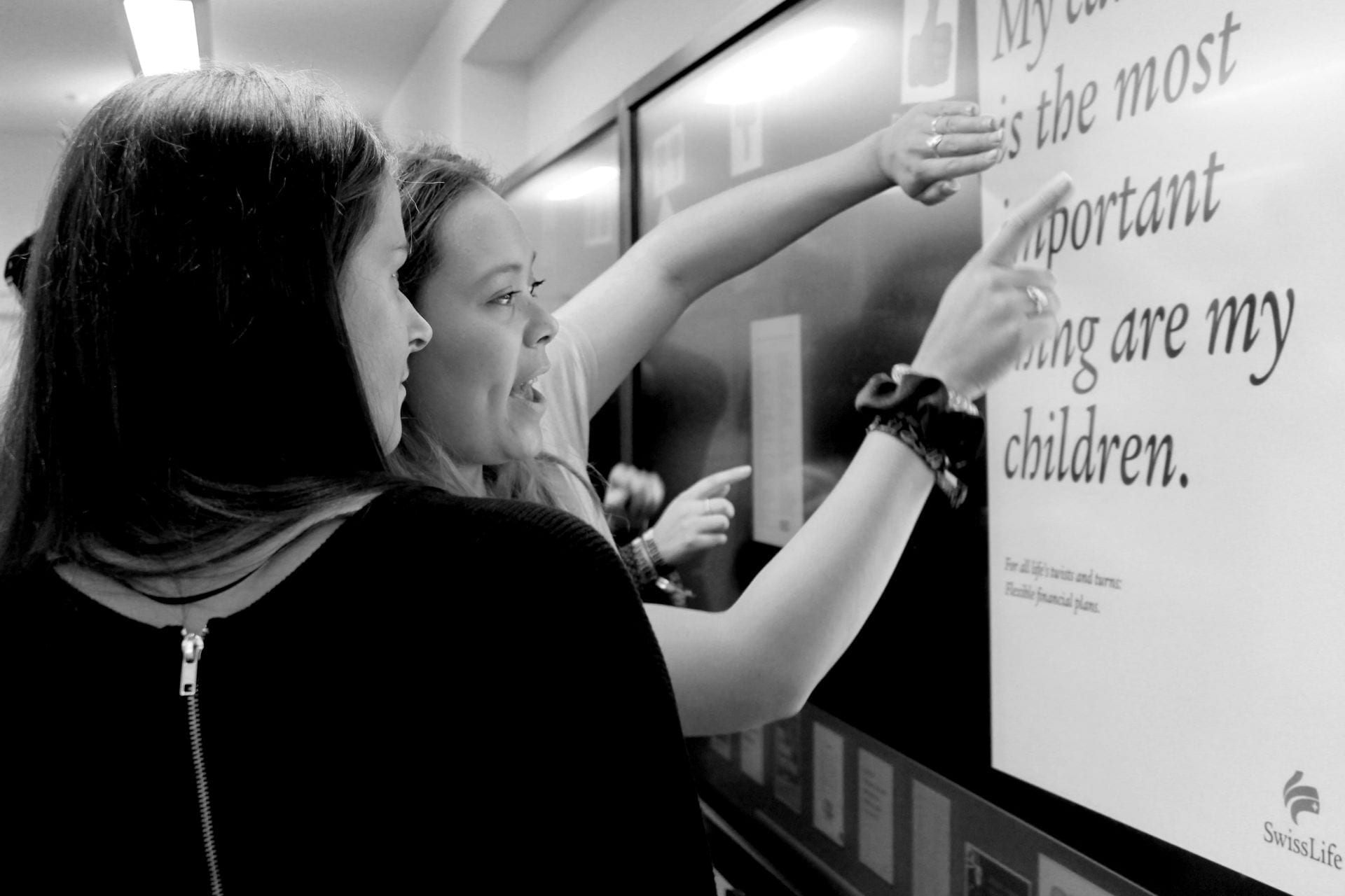 Two female students pointing at an interactive whiteboard