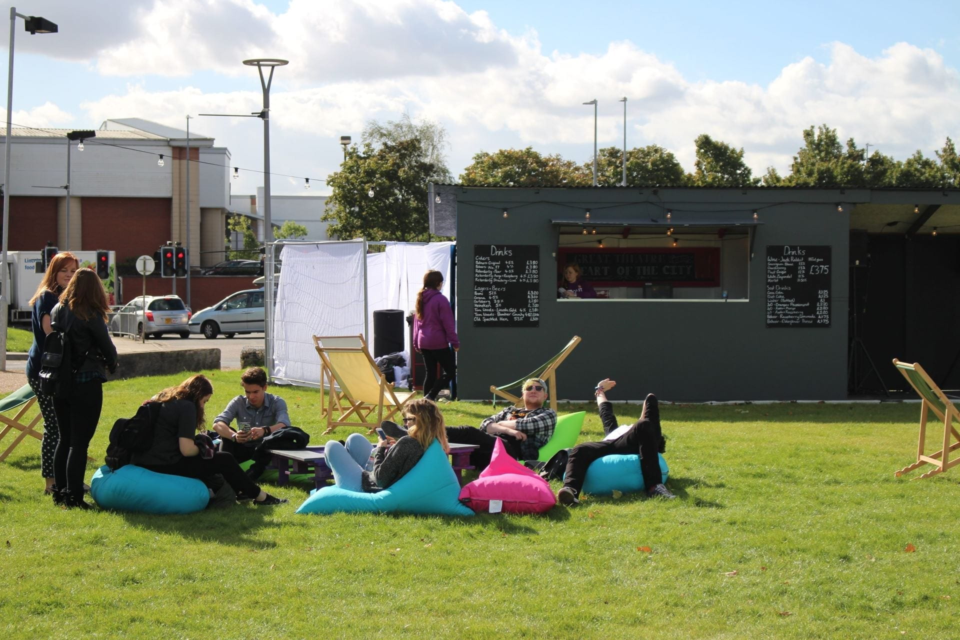Students sitting on multi-coloured bean-bags outside temporary bar