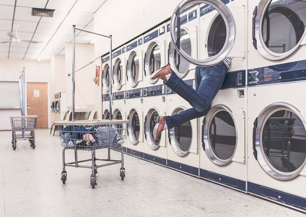 Laundry room, with a person leaning in to a washing machine.