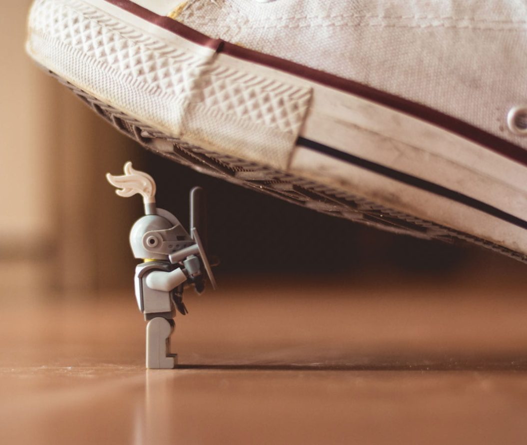 Close up shot of a lego knight almost being stepped on by a converse shoe