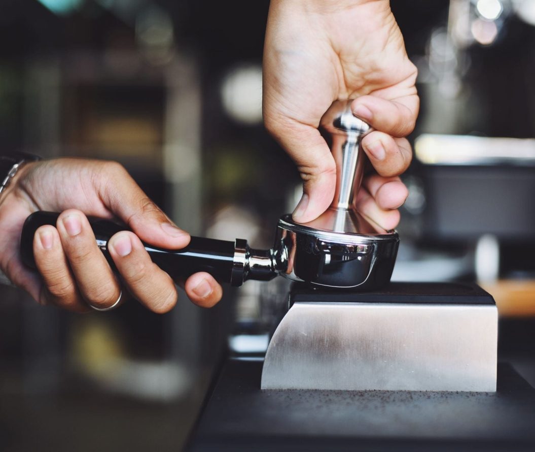 Close up of a man pressing coffee