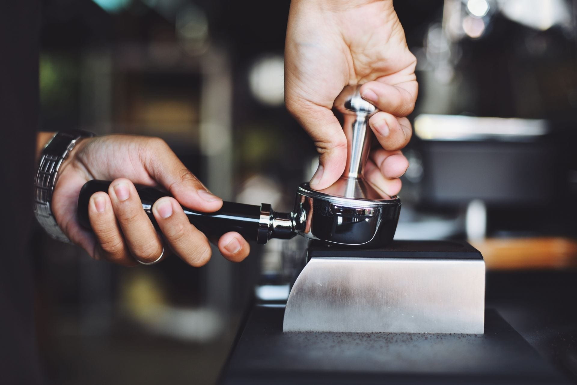 Close up of a man pressing coffee