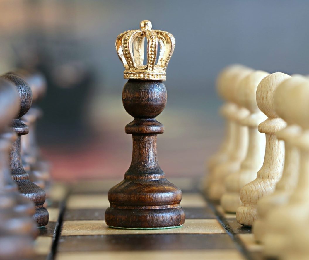 A close up of a chess pawn wearing a king's crown