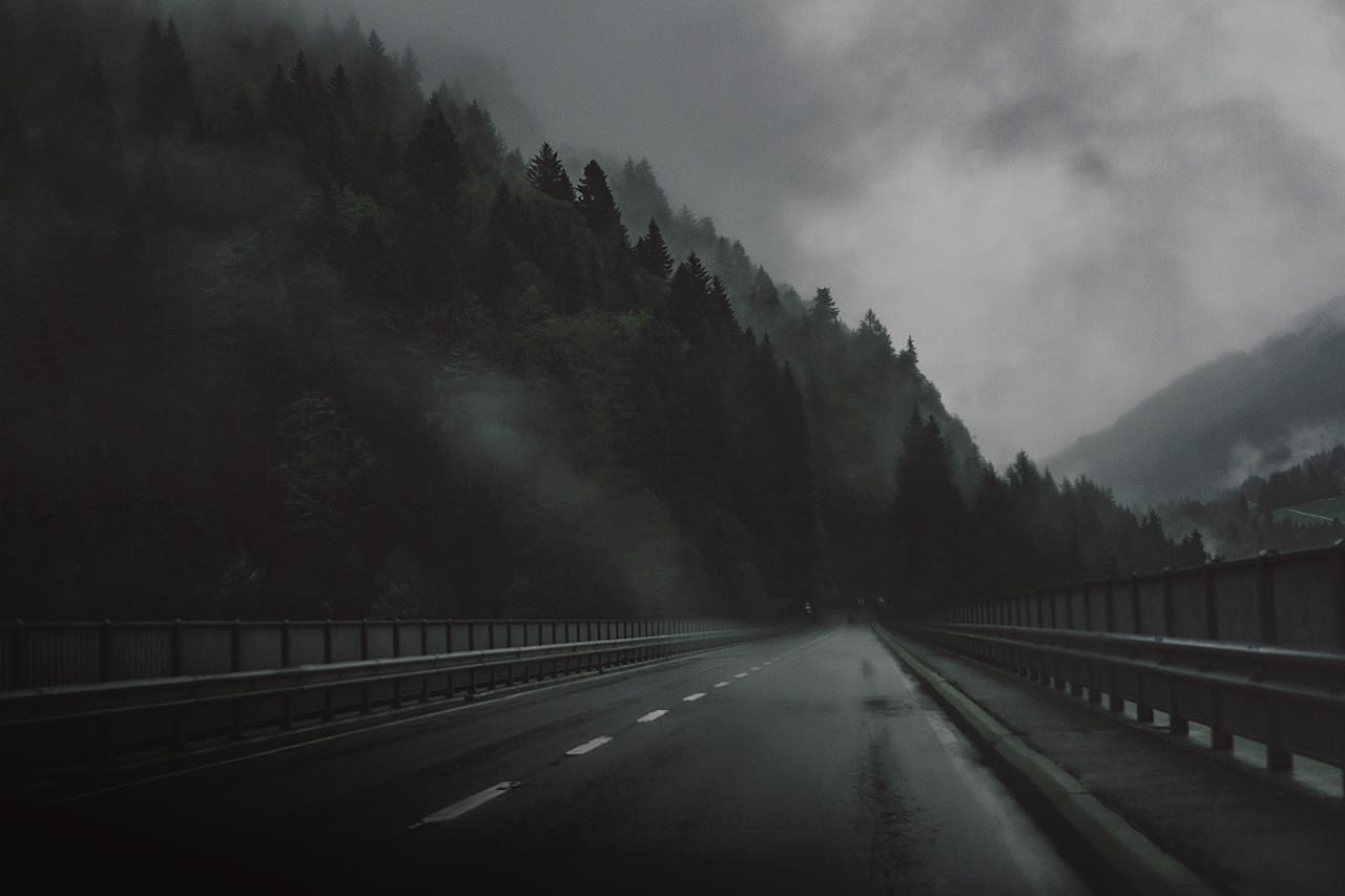 A long road on a foggy landscape in the mountains