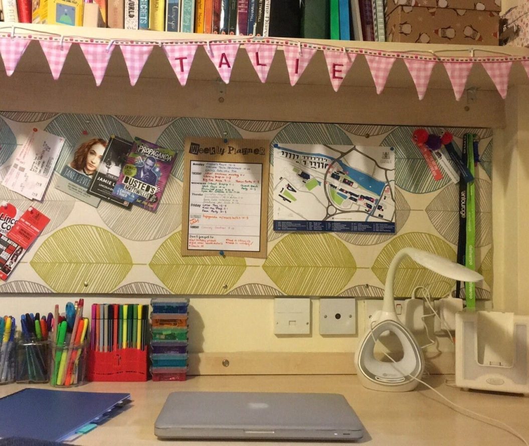 Students desk at home, with stationery and a laptop.