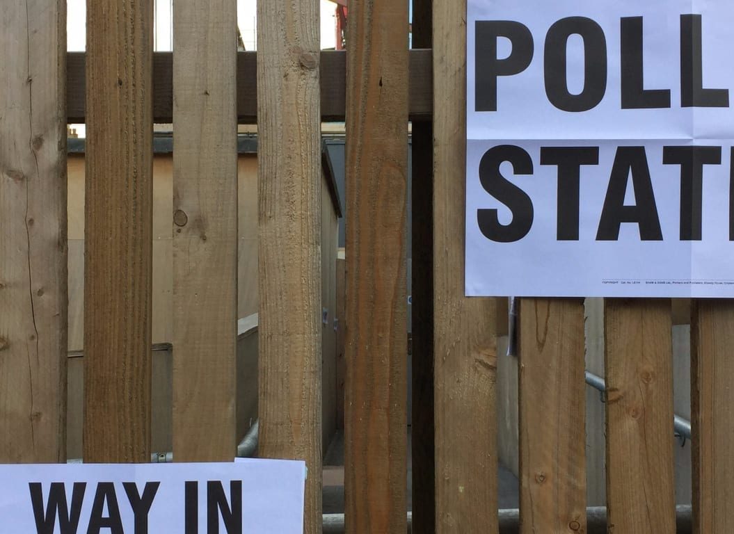 Polling station posters on a fence