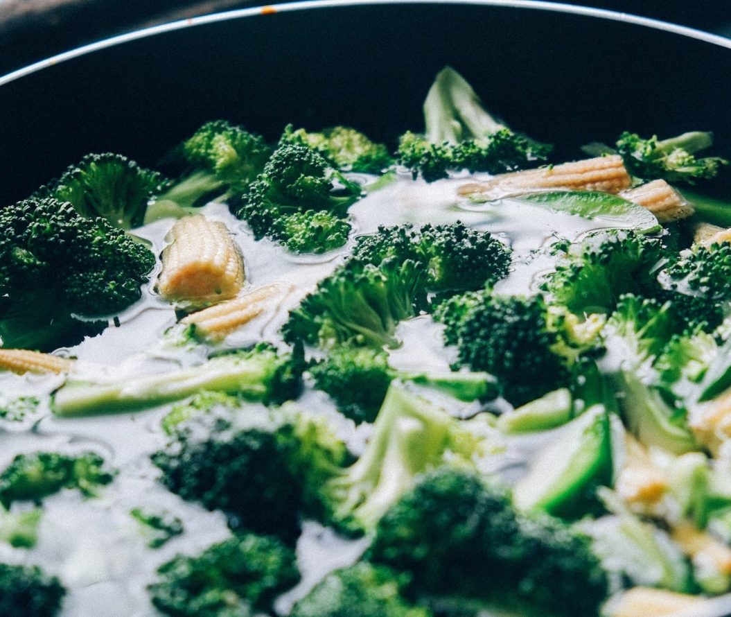 Broccoli, sweetcorn and snap peas, in a pan of water.