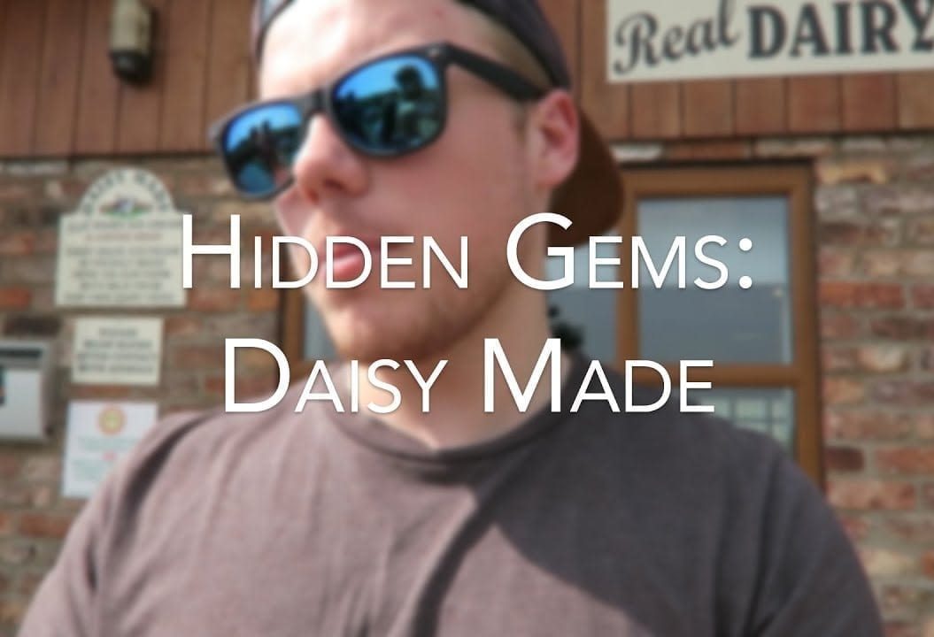 A young man wearing sunglasses stands in front of a building with the caption 'Hidden Gems: Daisy Made'