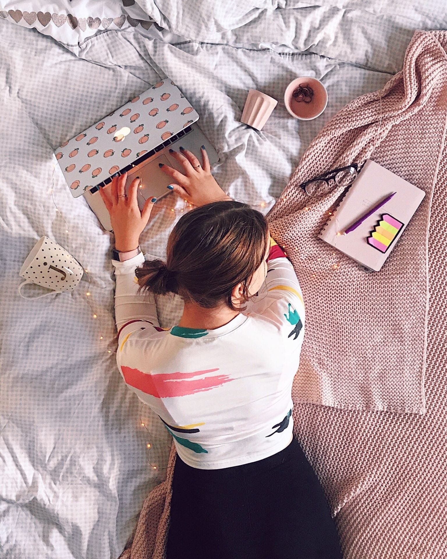 Top down photo of a young woman studying on her bed