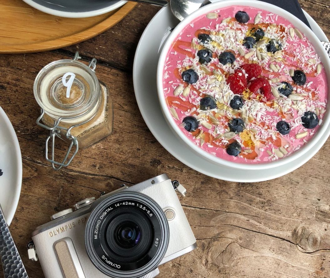 Camera and smoothie bowl in coffee shop