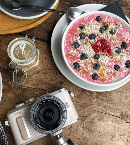 Camera and smoothie bowl in coffee shop