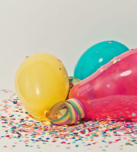 Multicoloured balloons surrounded by confetti
