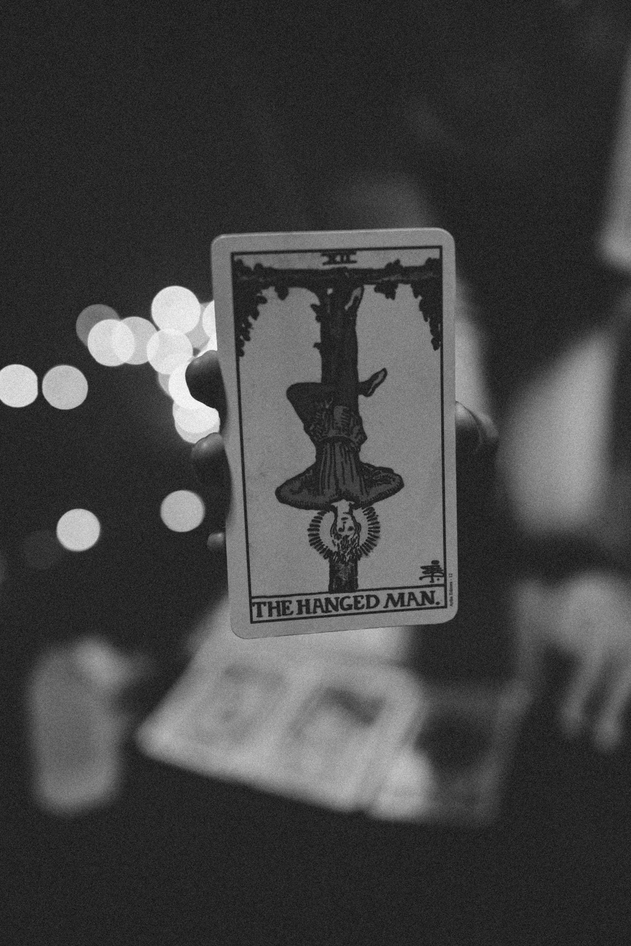 Black and white tarot card depicting the hanged man.