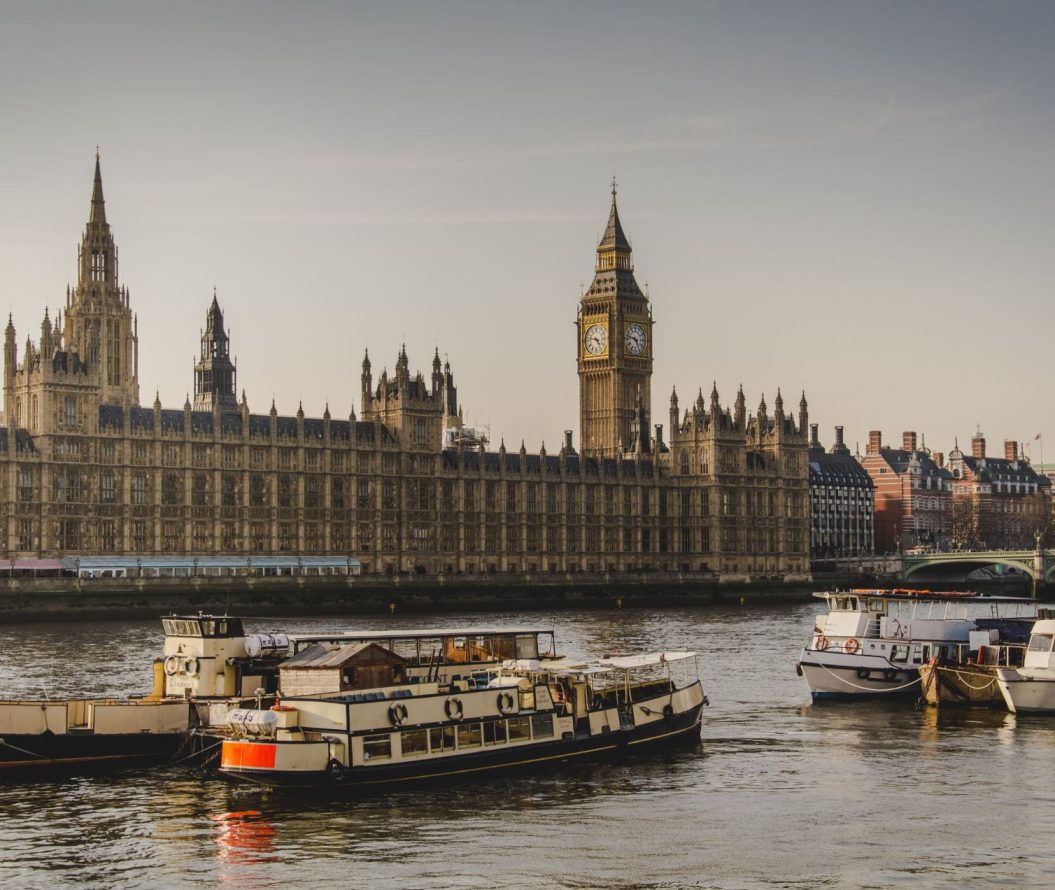 A photo of the parliament buildings in London. Boats can be seen in the river in front.