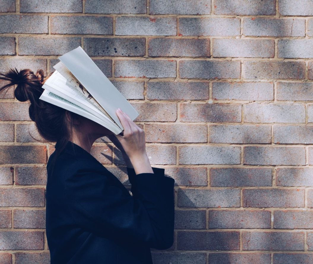 woman putting her head into a book