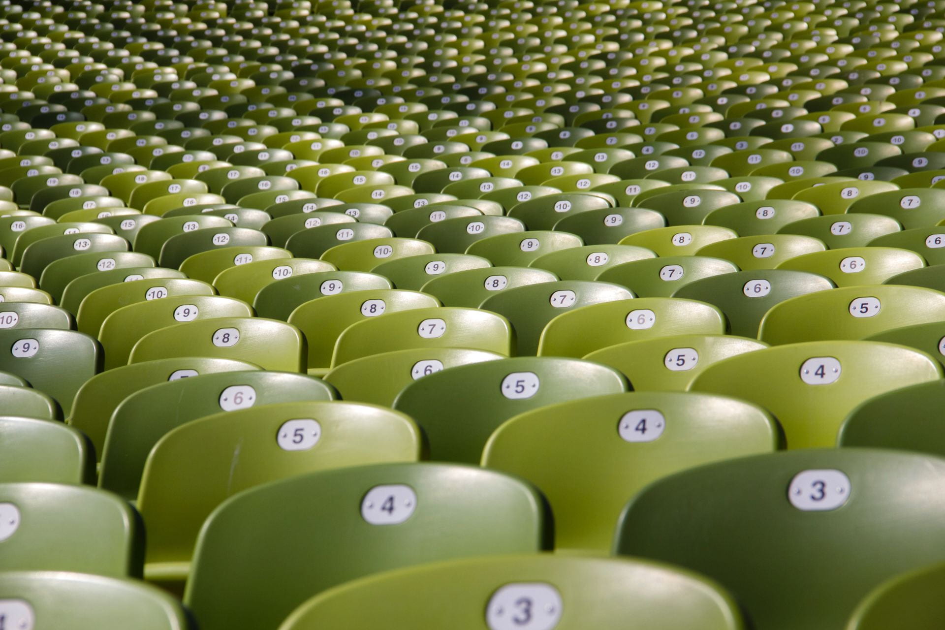rows of green chairs that are all numbered