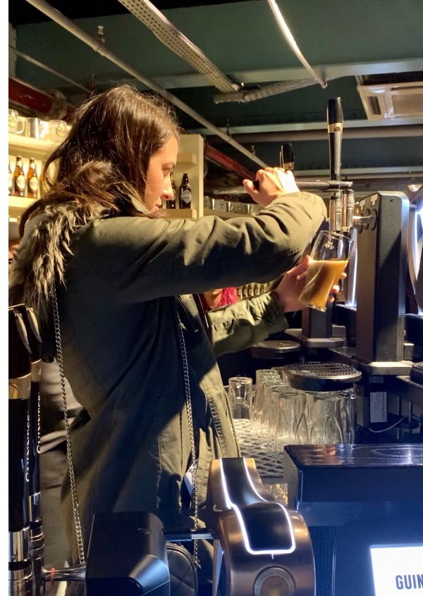 Woman Learning how to pour the perfect pint at the Guinness Storehouse