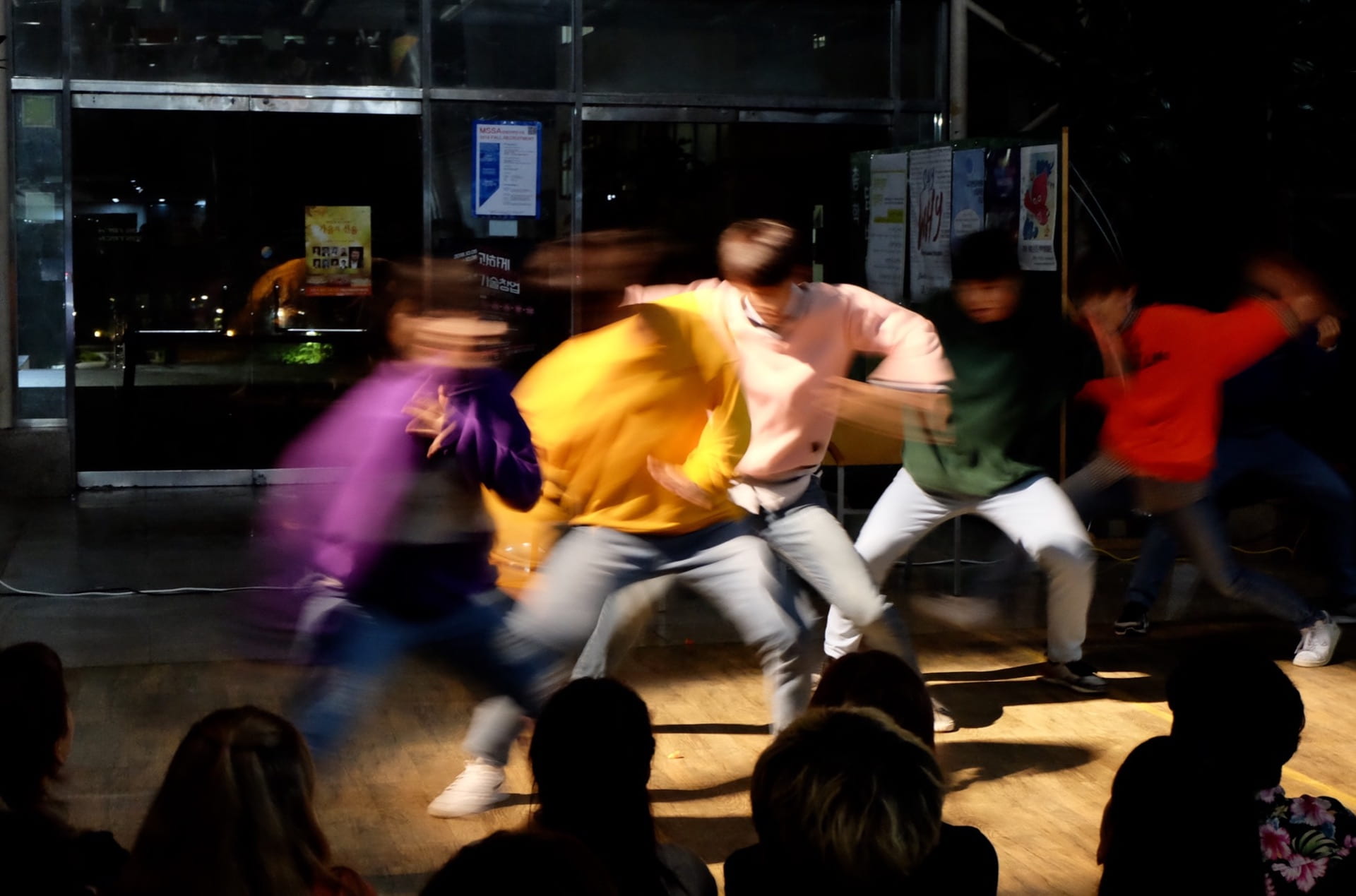 Five men dancing - the image is very blurred as they are moving quickly