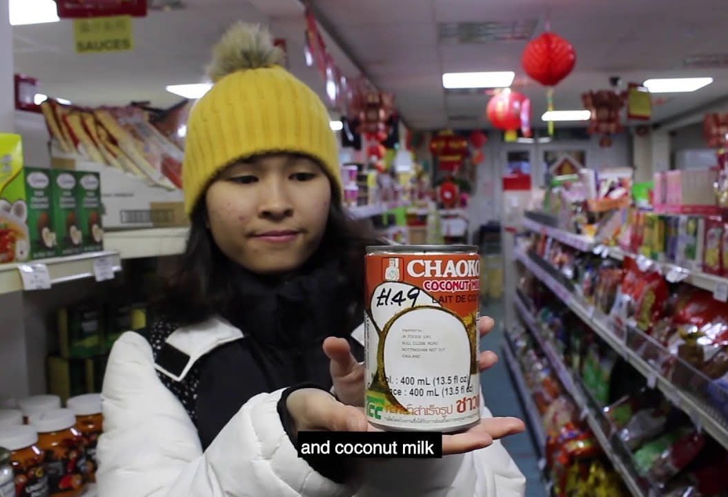 Girl in a supermarket holding coconut milk.
