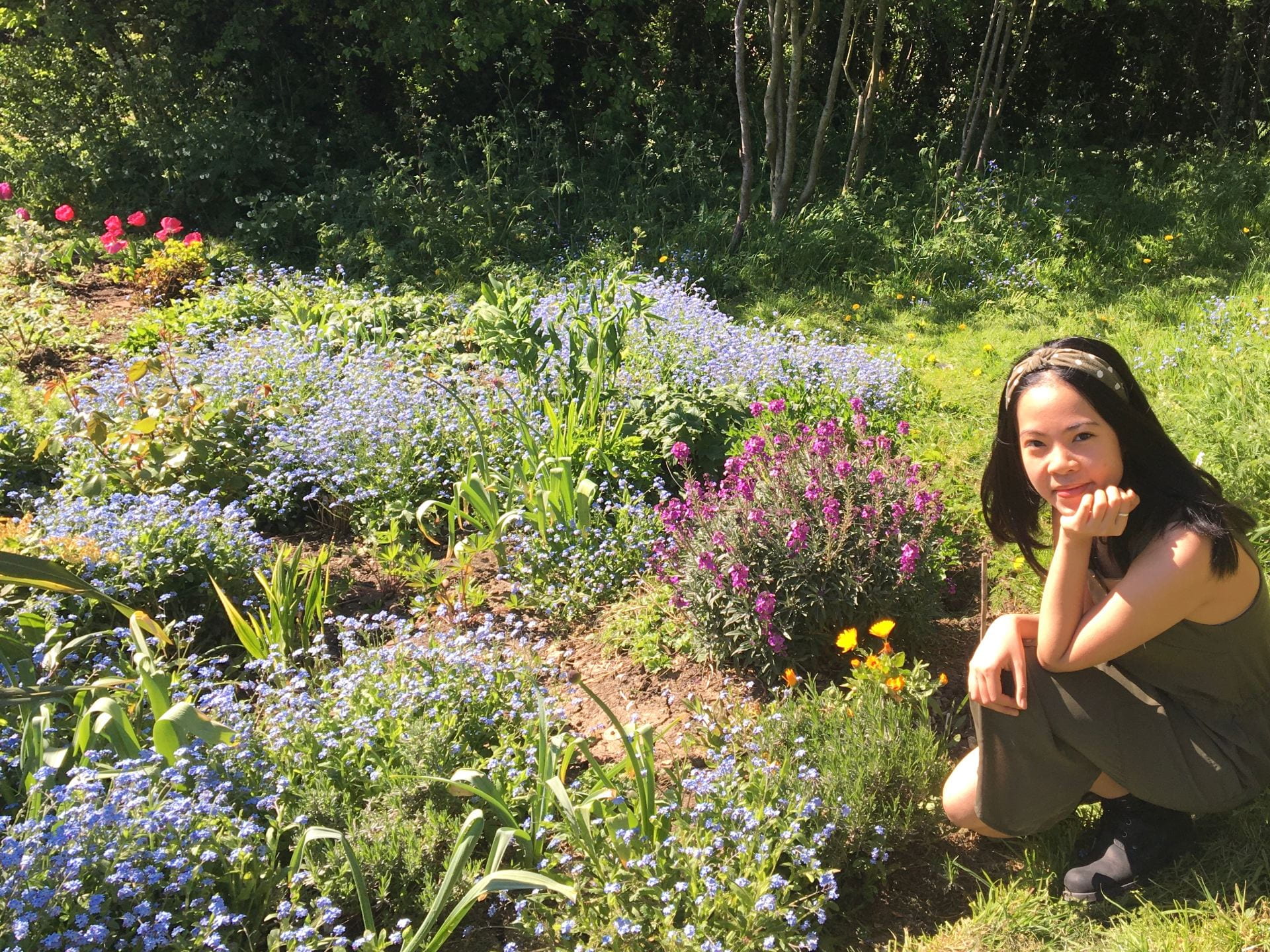 A girl smiling whilst sat in a garden