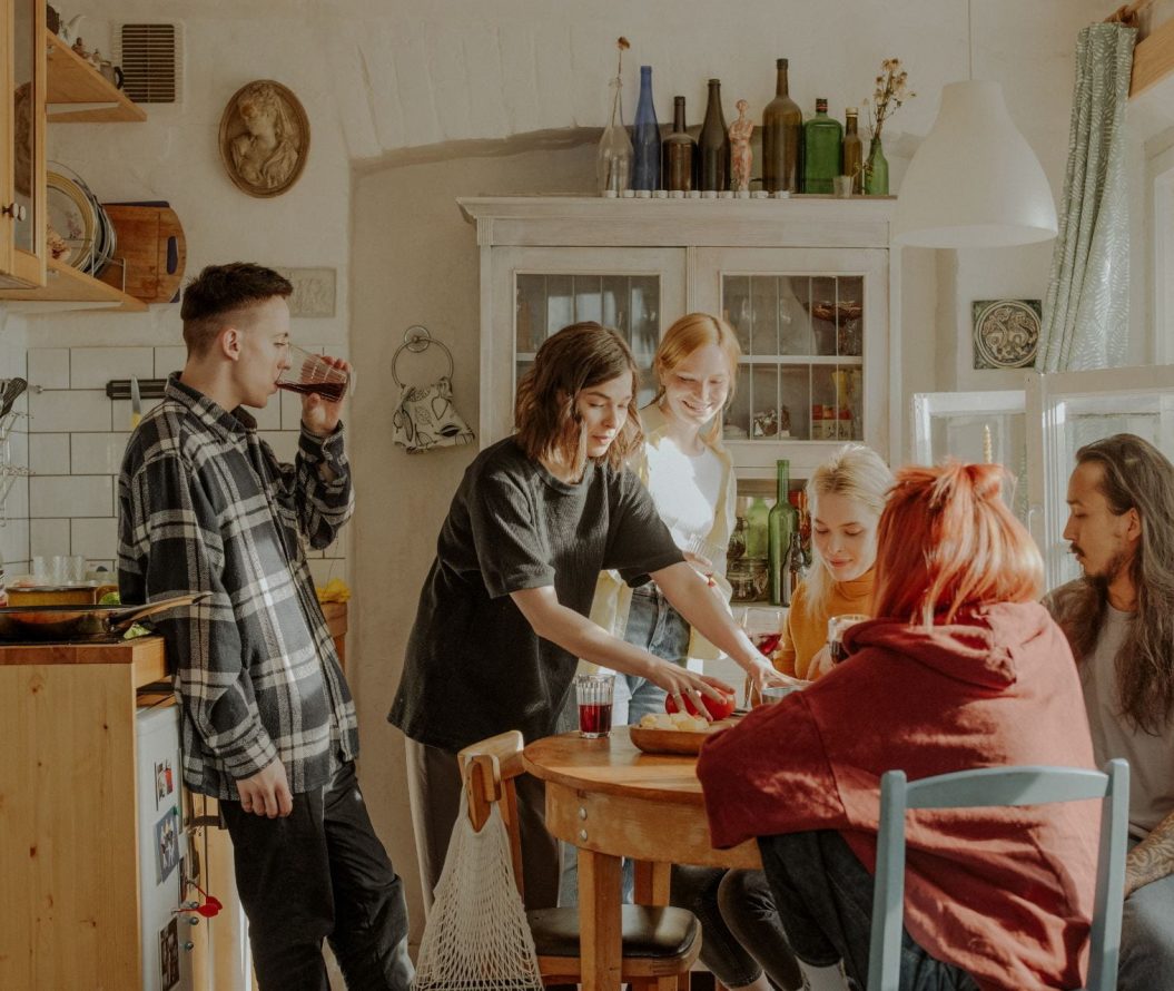 Group of friends sat in a kitchen chatting to each other