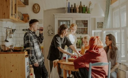 Group of friends sat in a kitchen chatting to each other