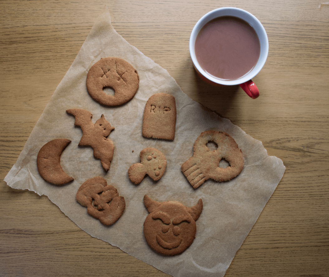Flatlay showing handmade halloween biscuits sat next to a mug of tea