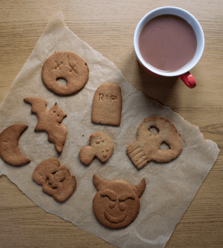 Flatlay showing handmade halloween biscuits sat next to a mug of tea