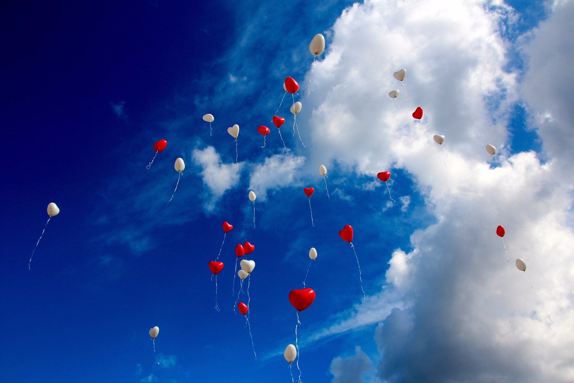 Heart shaped red and white balloons in the sky