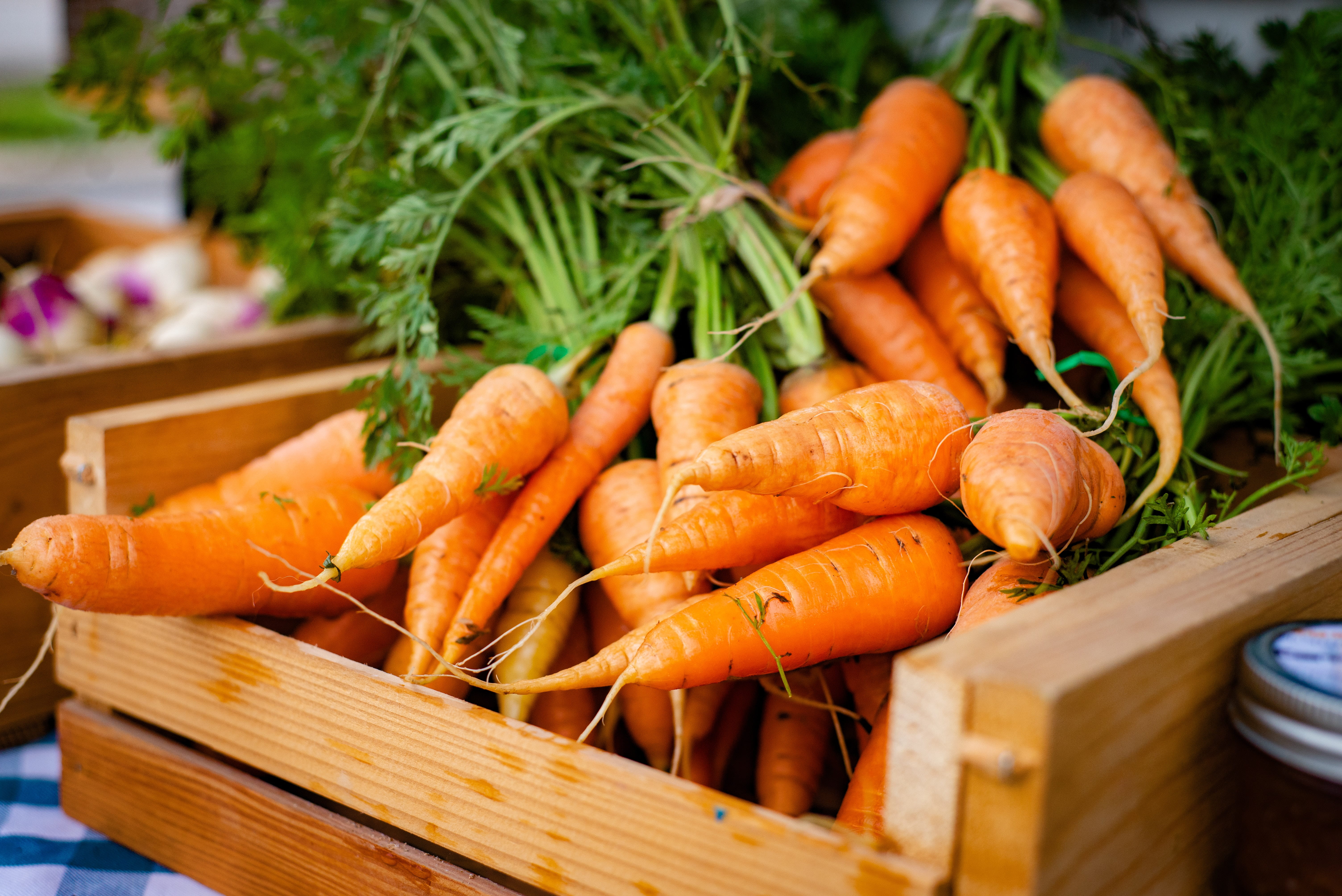 A wooden box filled with carrots.