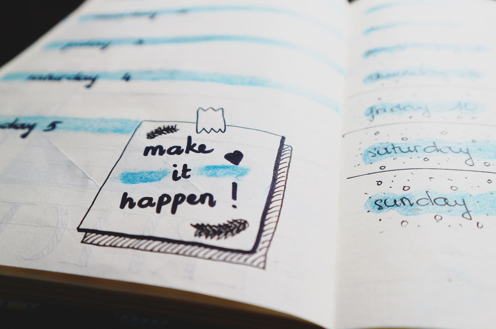 The inside of a planner. There is a drawing of a post-it note with the words 'Make It Happen!' on it.
