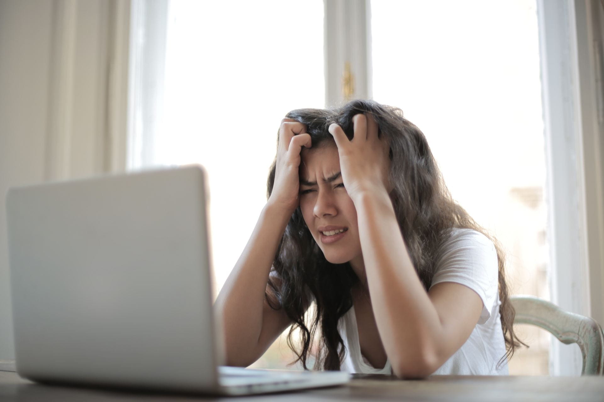 Woman looking stressed in front of laptop