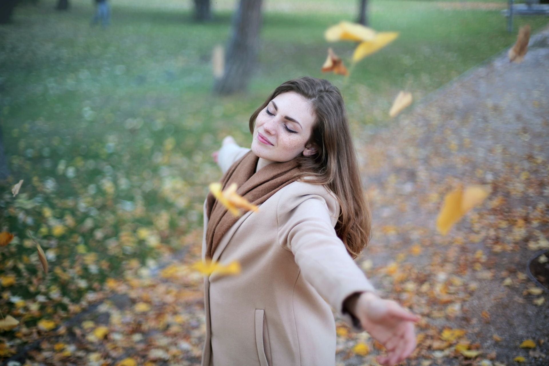 Woman outside in falling leaves