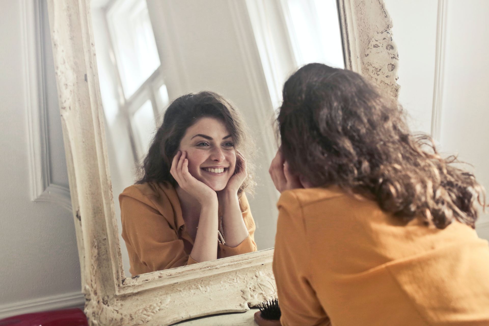 Woman smiling at herself in a mirror