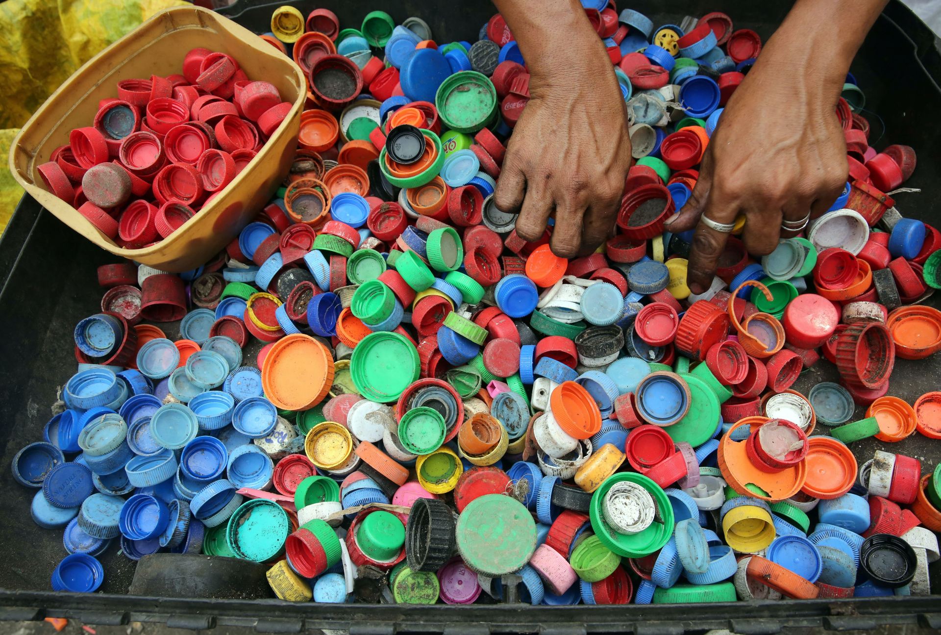 A tray full of hundreds of bottle tops