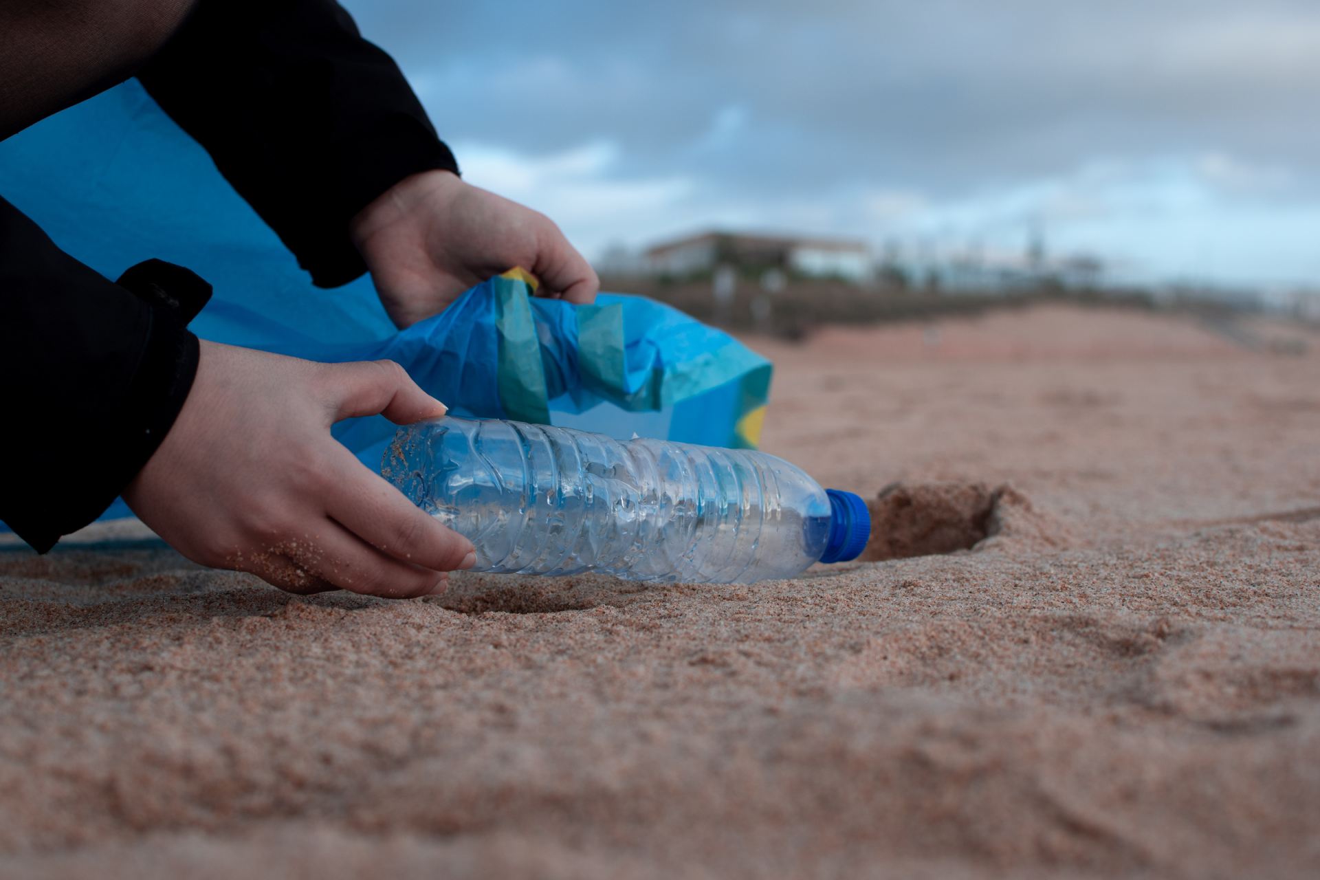 Picking up a plastic bottle from the beach