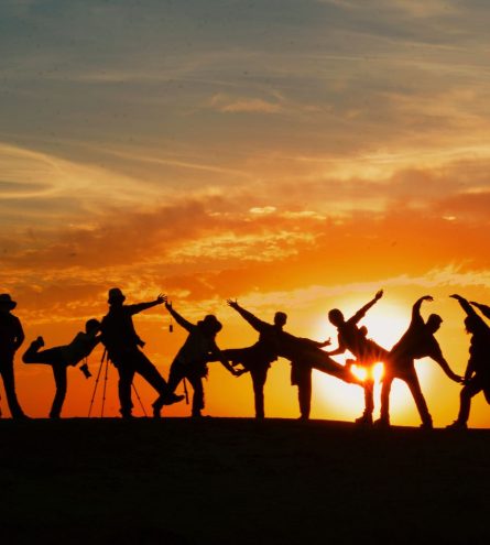 A group of people taking part in yoga in the sunset