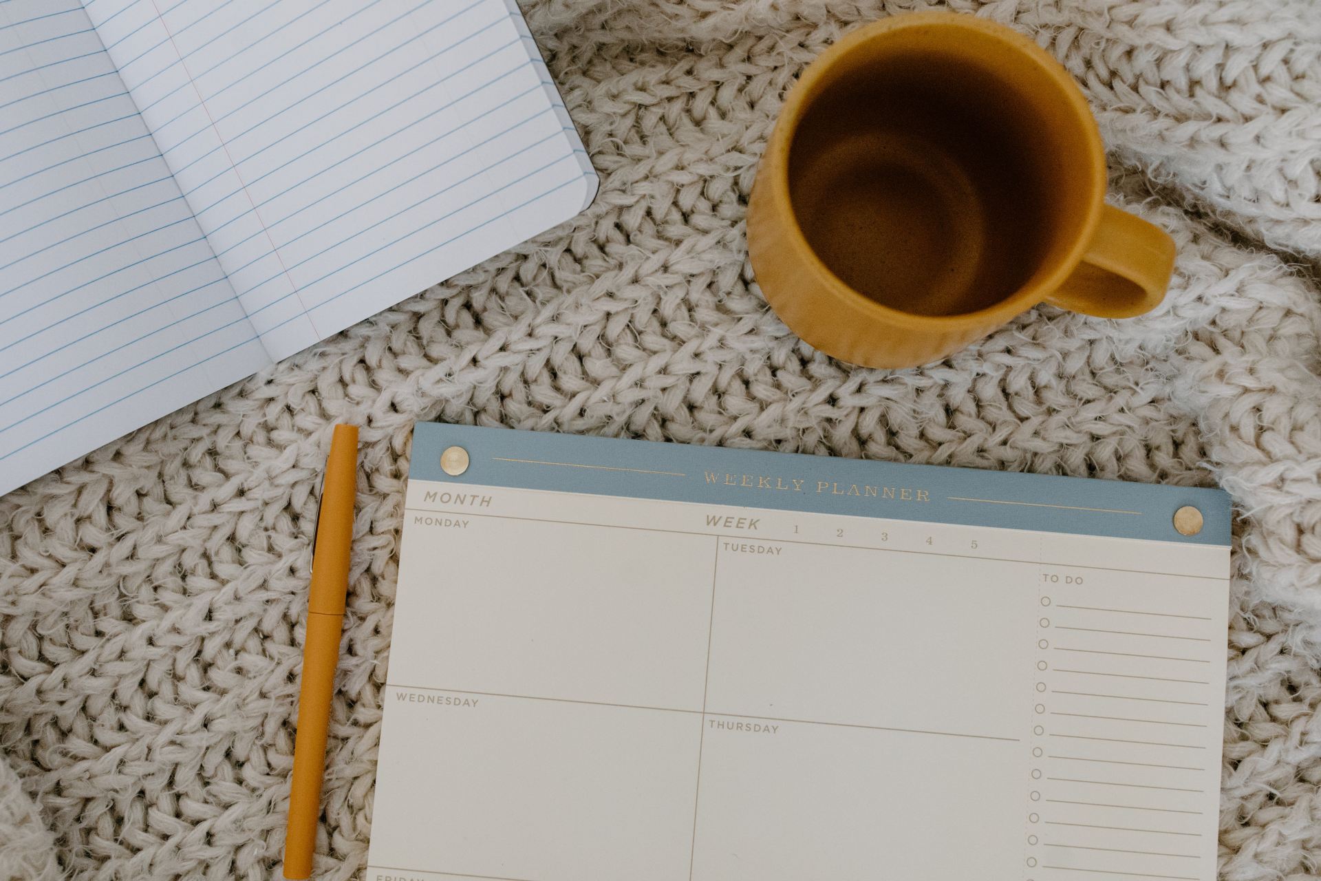 A close up a coffee cup and a weekly planner