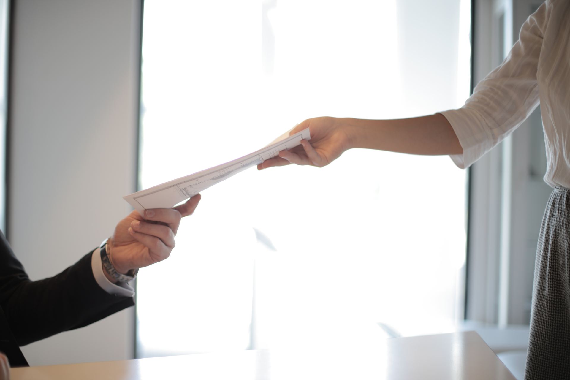 Someone handing a document to another person