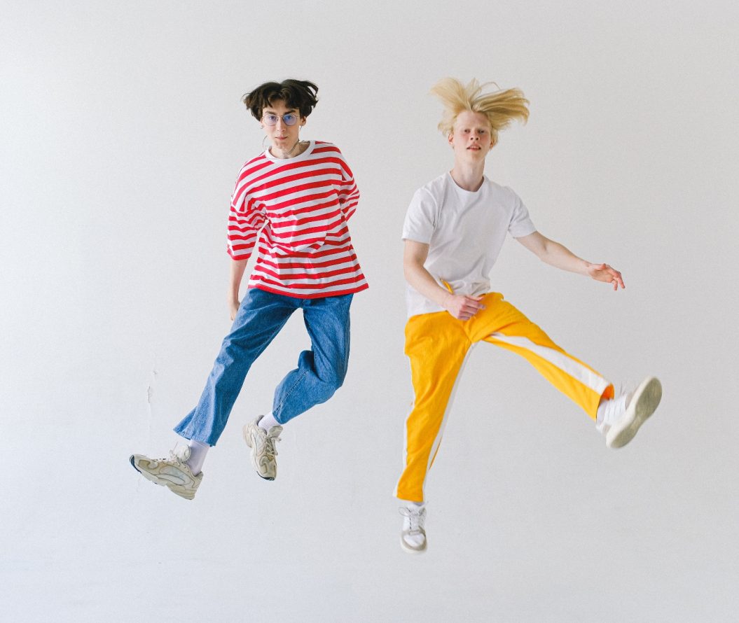 two people jumping on a white background