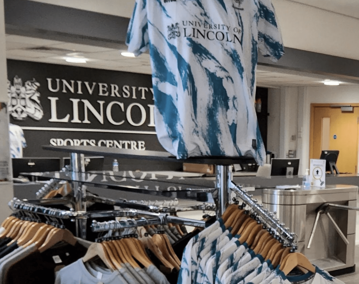 A picture of the gift shop in the university of lincoln sports centre gym showing football t-shirts for sale