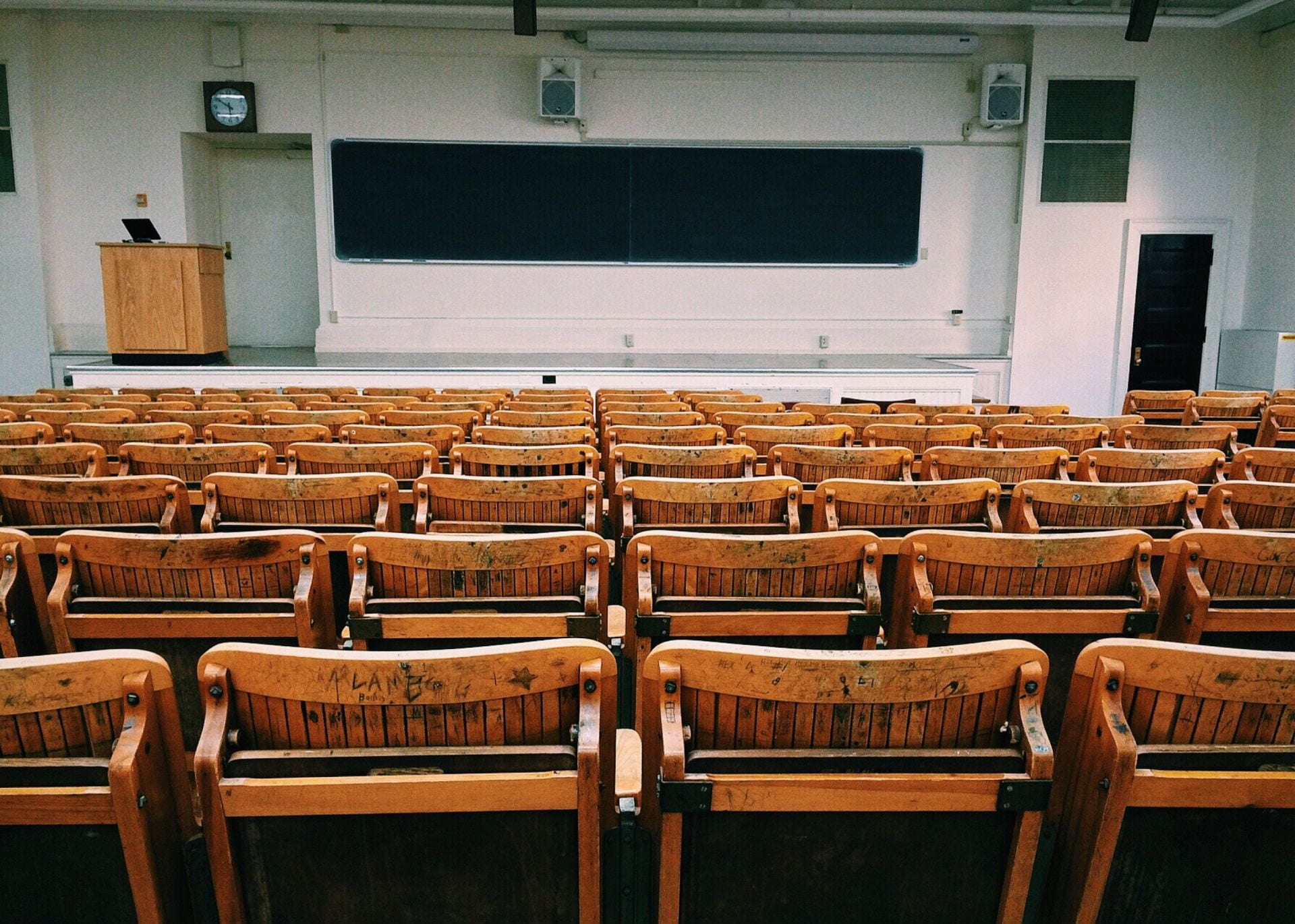 A lecture hall with chalkboards and old wooden chairs