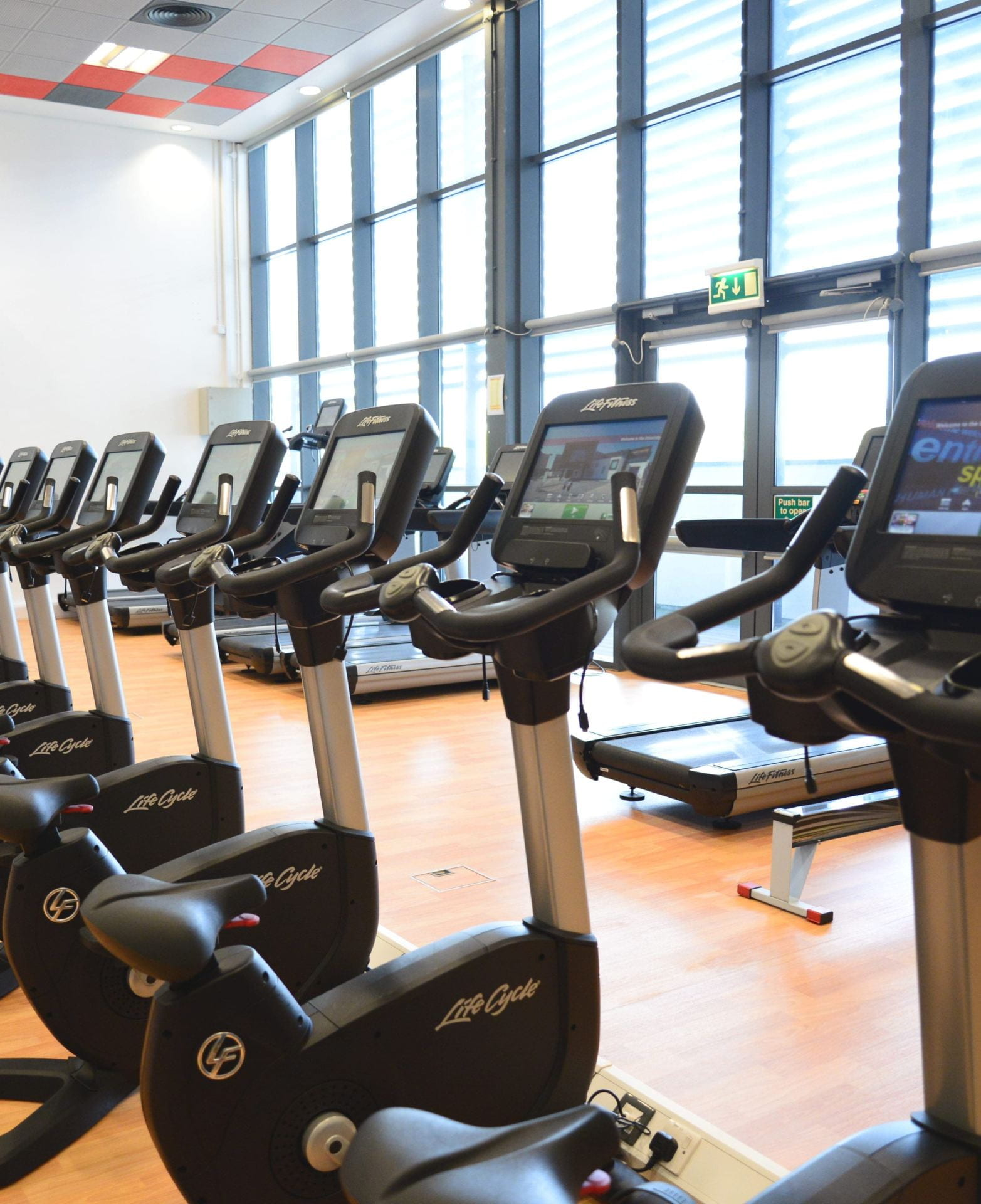 A picture of stationary bikes in the university of Lincoln gym, in front of treadmills