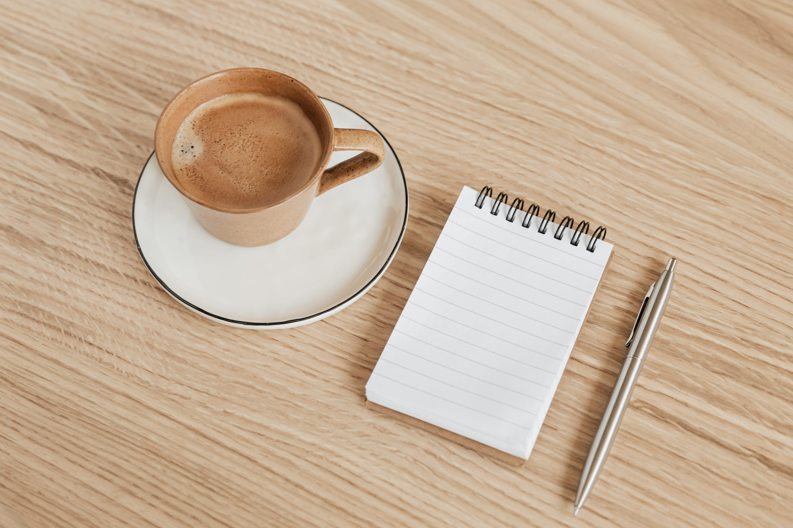 Coffee cup, notepad and pen