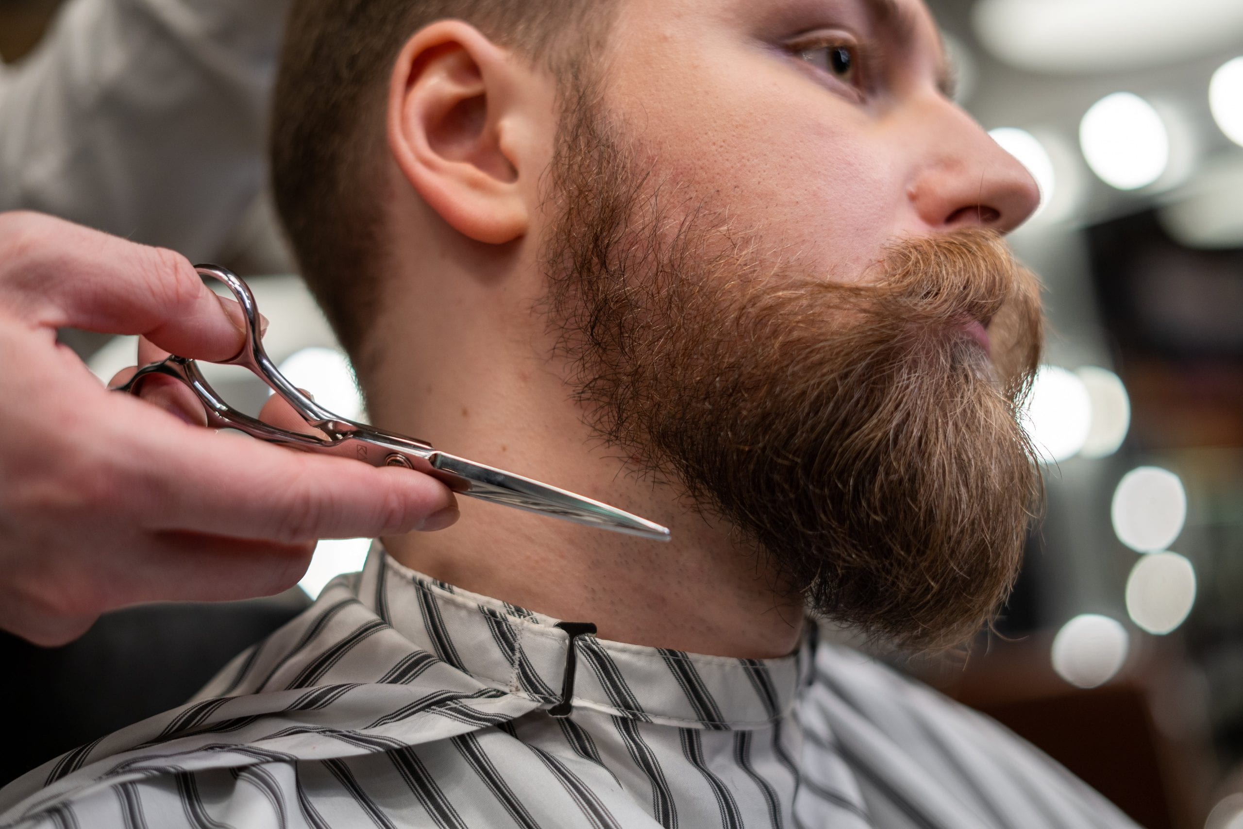 Man getting his beard cut with a moustache