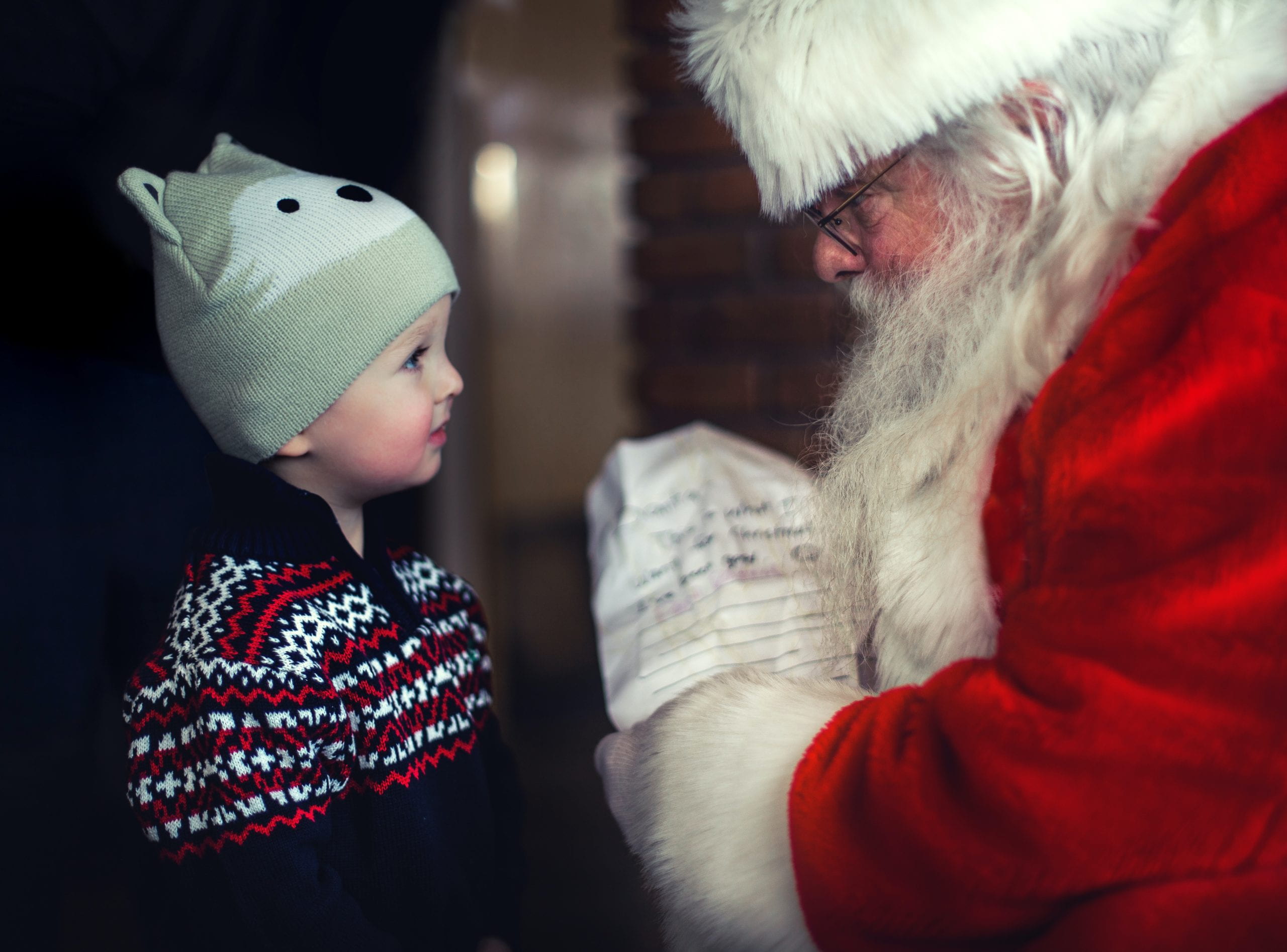 Santa giving a young boy a present.